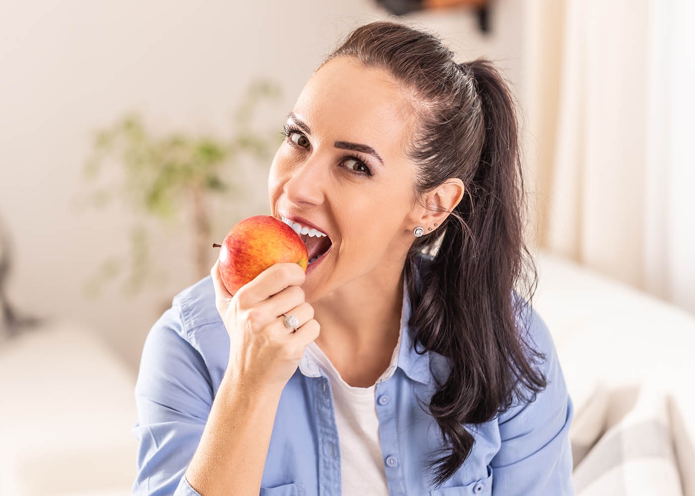 dental implant functionality - lady eating an apple